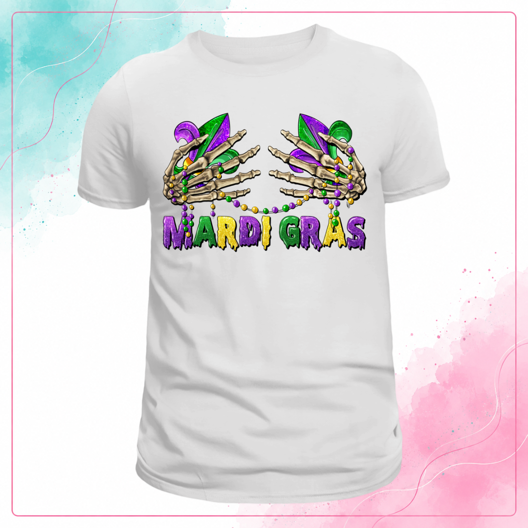 White Mardi Gras T-shirt with skeleton hands, fleur-de-lis, bead necklaces, and purple, green, and gold lettering.
